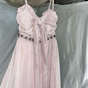 Purple dress high in front hangs low in back with silver hardware around waist.